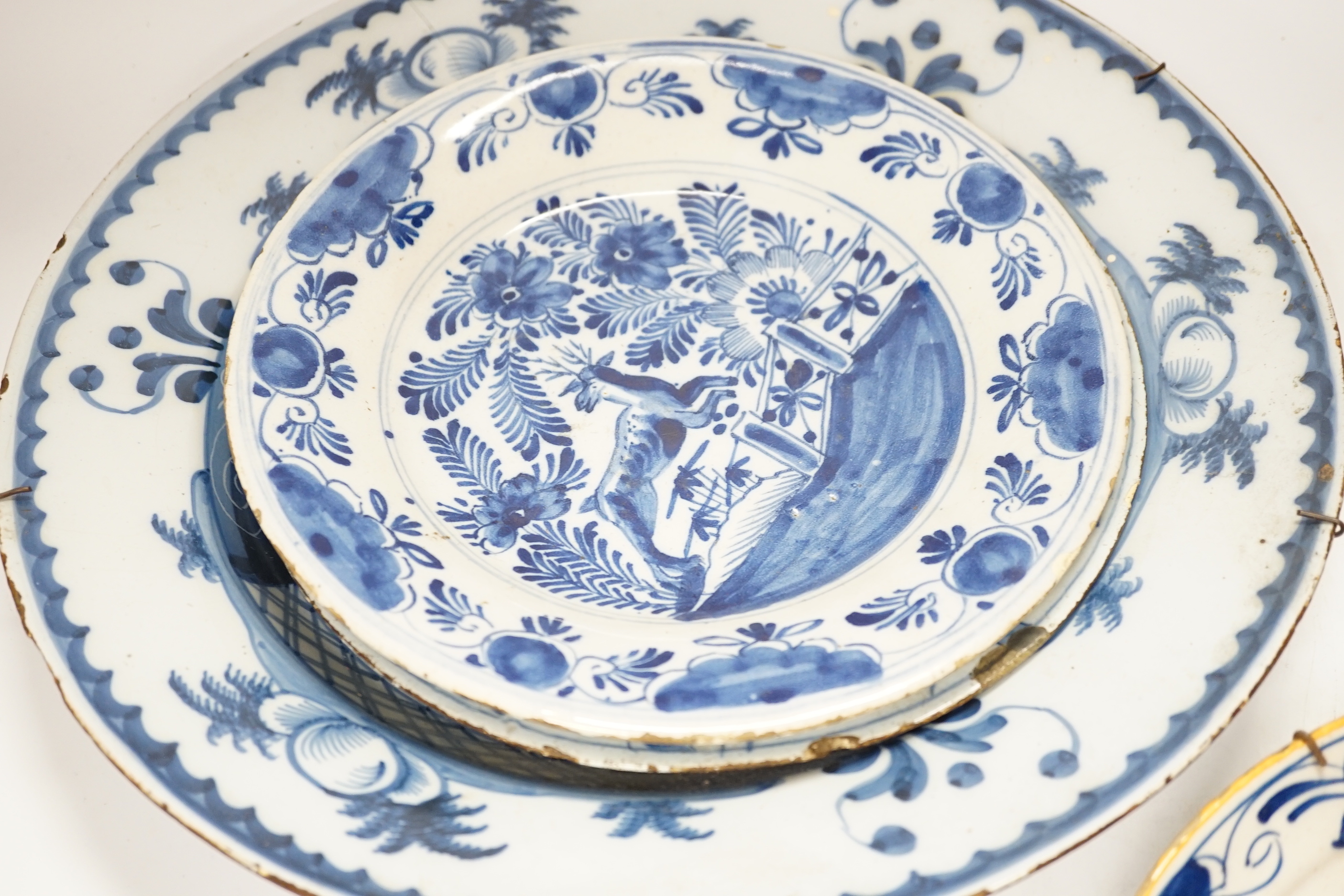 Five 18th century assorted Delft dishes and a plate, largest 35cm diameter